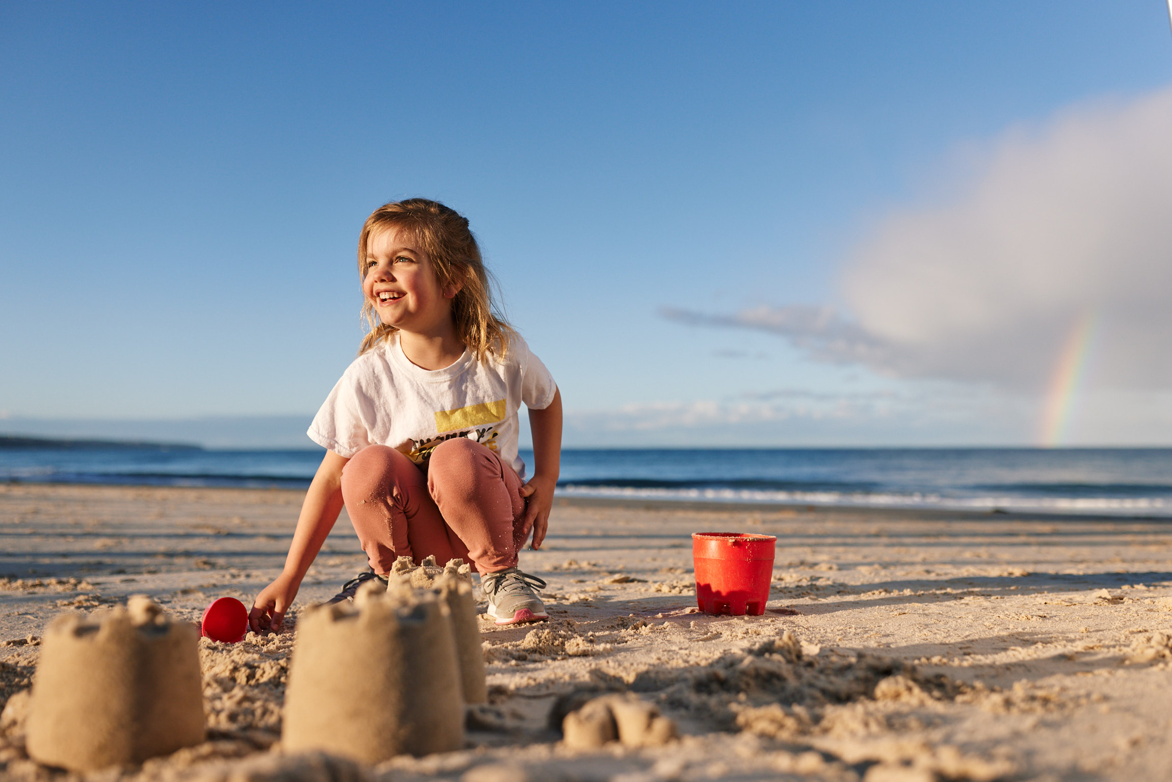 ZEN Energy girl smiling making sand castles on beach